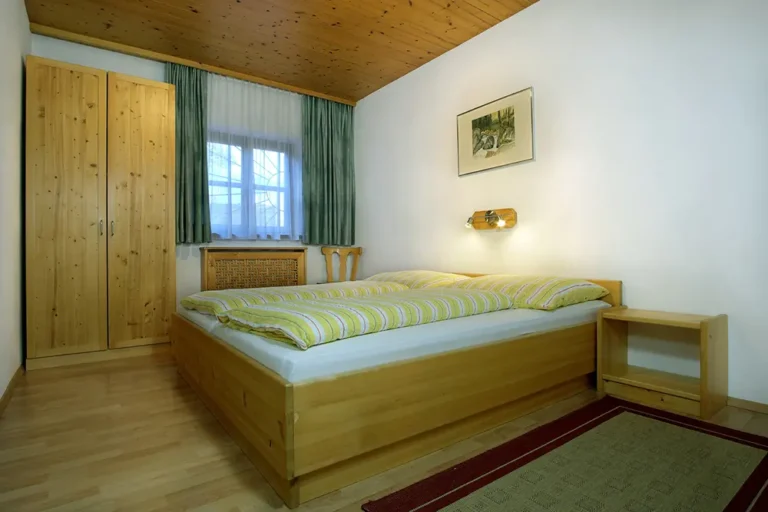 helles Schlafzimmer Kleiderschrank, Doppelbett aus Kiefernholz und Fenster