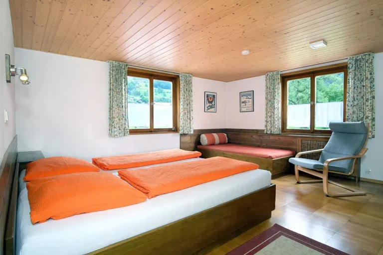 helles Schlafzimmer mit Doppelbett, Einzelbett und zwei Fenstern