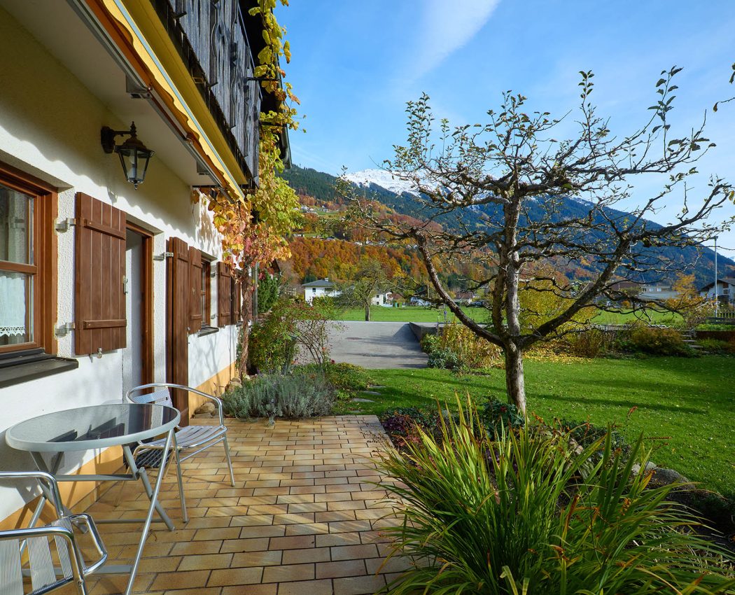 beige gelfießte Terrasse mit Blick auf Baum und das Bergpanorama im Hintergrund