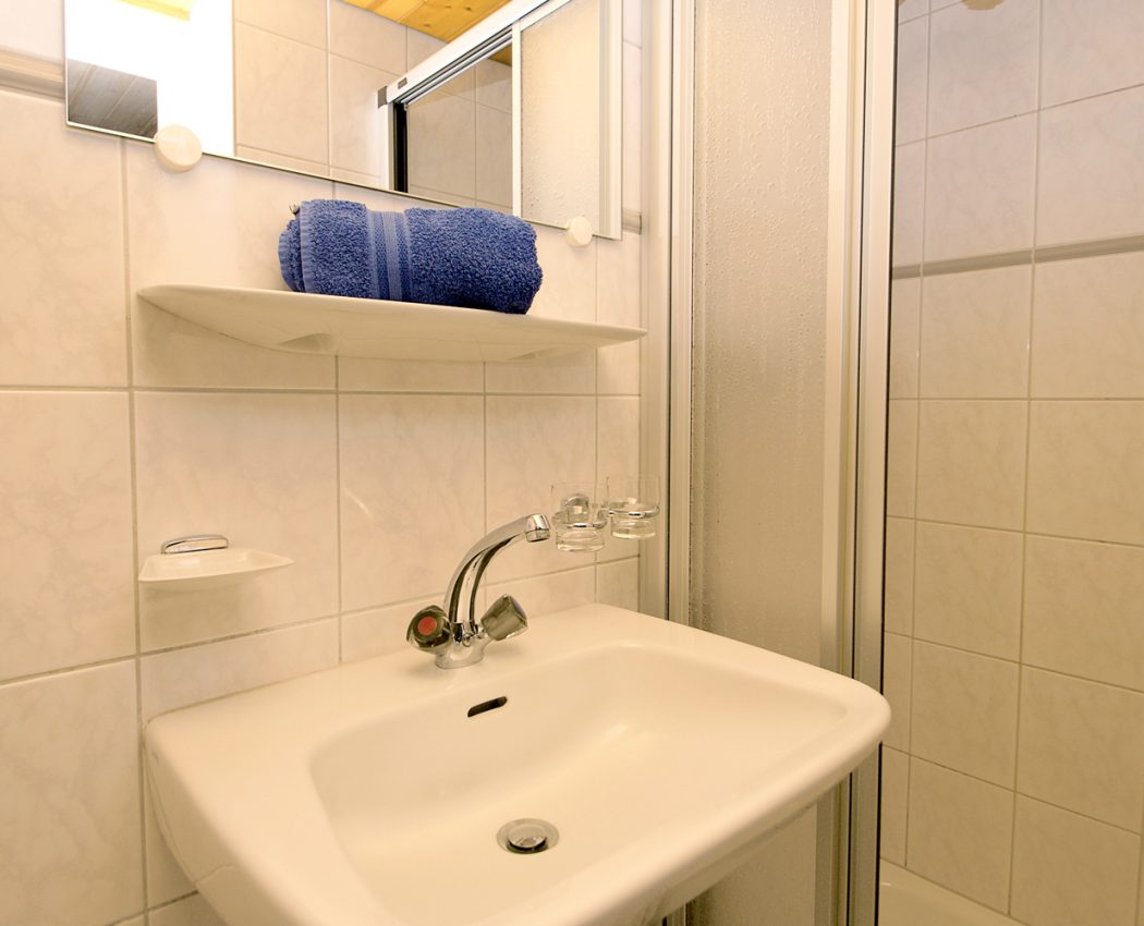 weißes Bad mit Waschbecken neben Duschkabine