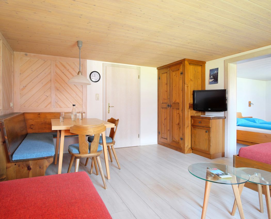 Helles Wohnzimmer mit Esstisch, Eckbank, Schrak und TV