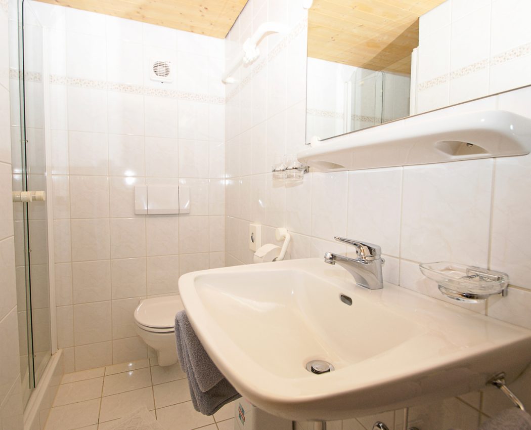 weißes helles Bad mit Waschbecken, Spiegel und Toilette